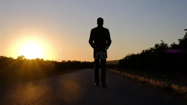 silhueta-de-um-homem-está-caminhandonuma-estrada